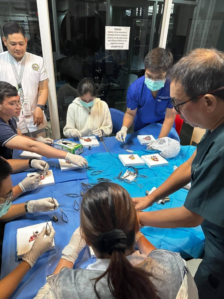 Participants and facilitators gathered around the cornea retrieval training table