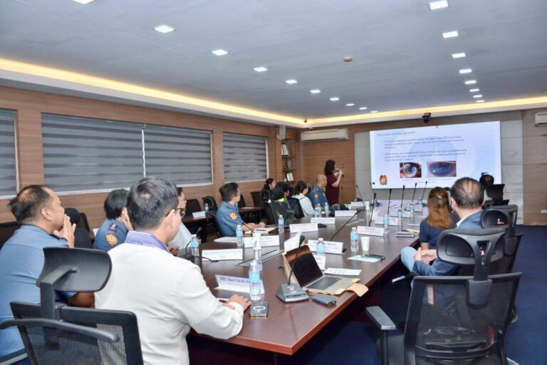 Wide view of the conference room with the presentation on screen