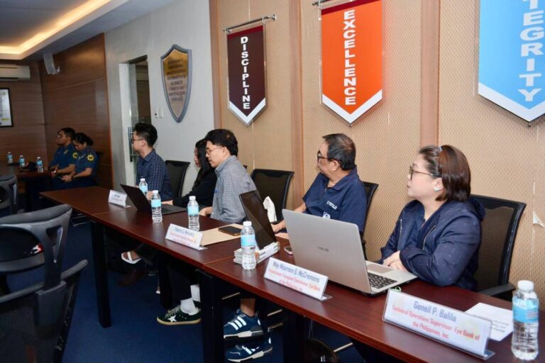 Attendees with laptops at the conference table